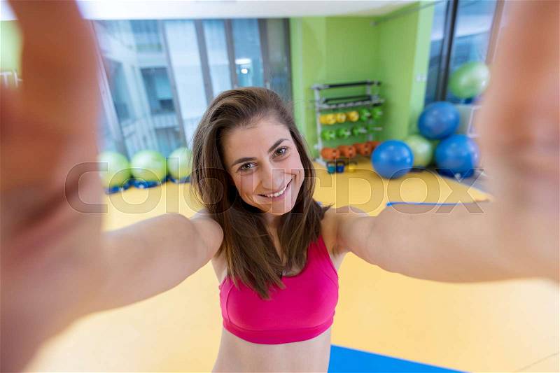 Sport woman smile at camera self picture at gym, young girl picture herself exercising fitness center, stock photo