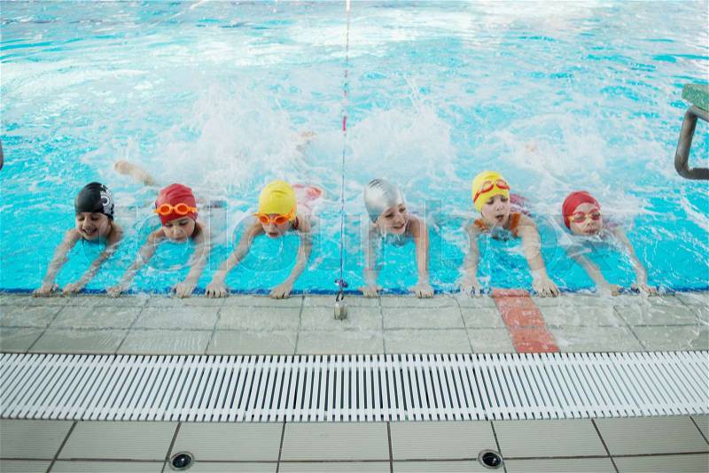 Happy children kids group at swimming pool class learning to swim, stock photo