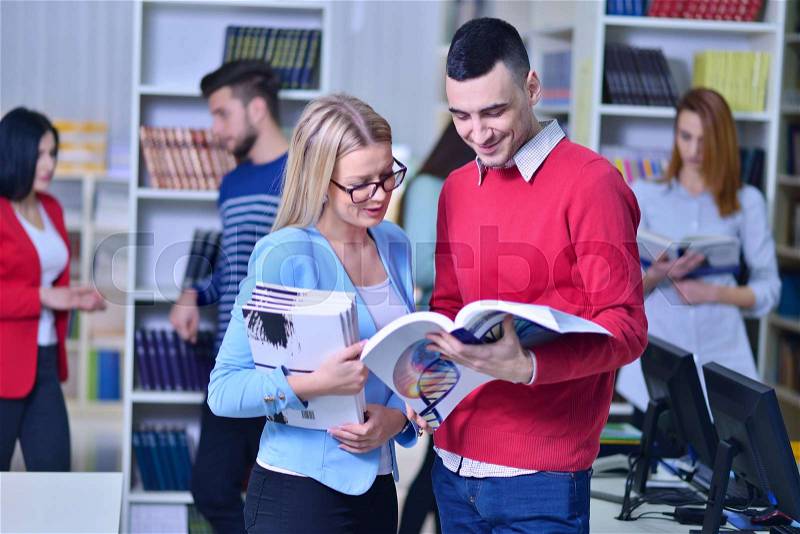Two young students working together at the library, stock photo