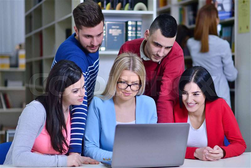 Group Of Students Working Together In Library With Teacher, stock photo