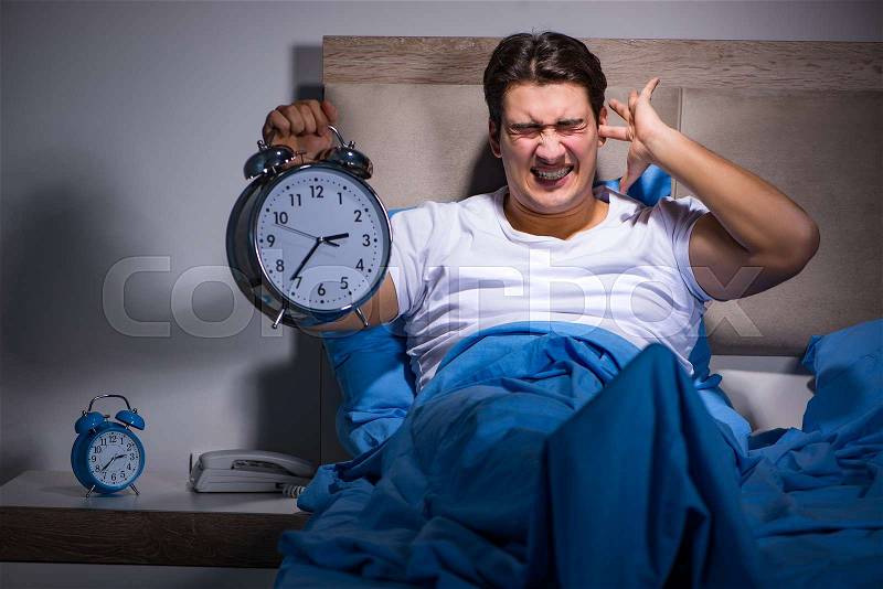 Man having trouble sleeping in bed, stock photo
