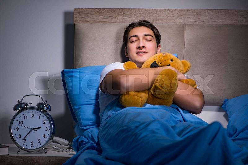 Young man sleeping in the bed, stock photo
