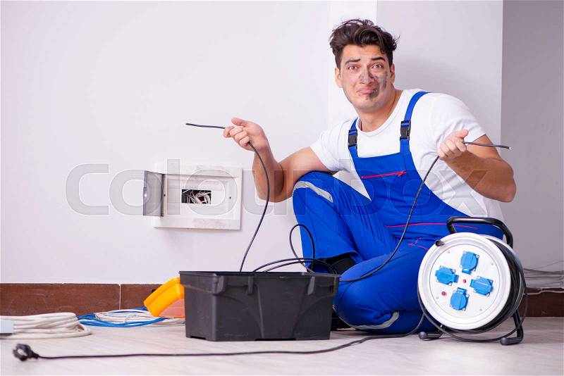 Funny Man doing electrical repairs at home, stock photo