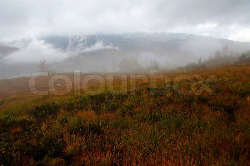 Fog in the mountains in autumn A cabin in almost hidden in the fog, stock photo