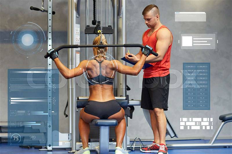 Sport, fitness, teamwork and people concept - young woman and personal trainer flexing muscles on gym machine over virtual charts, stock photo