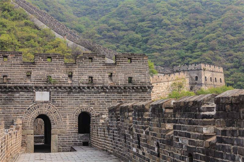 Entrance to watchtower of the Great Wall of China on the Mutianyu section with scenic mountain slope on the background, stock photo