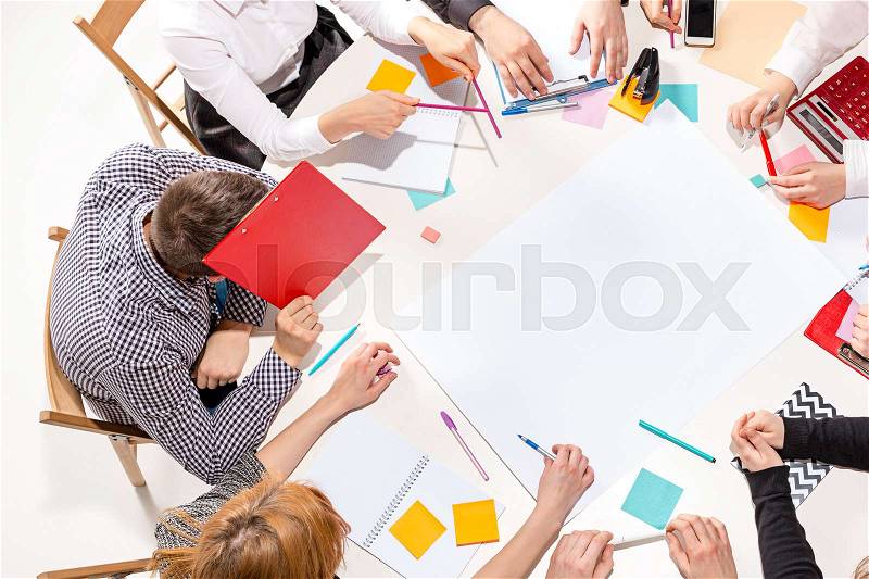 Team sitting behind desk, checking reports, talking. Top View. The business concept of collaboration, team work, meeting, stock photo
