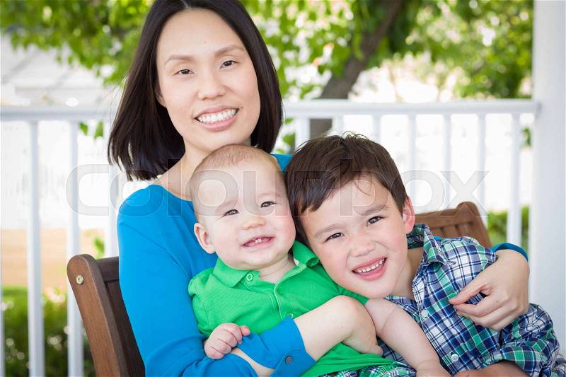 Outdoor Portrait of A Chinese Mother with Her Two Mixed Race Chinese and Caucasian Young Boys, stock photo