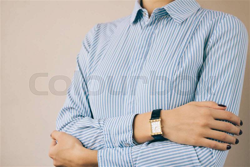 Cropped image of a woman in a business shirt and watch, close-up, stock photo