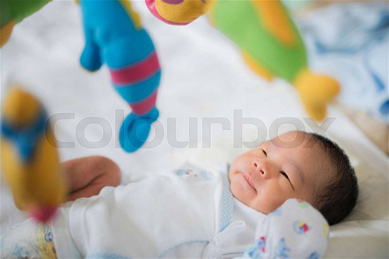 Baby sleep in cot with over head fish mobile, stock photo