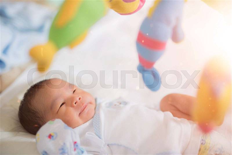 Baby sleep in cot with over head fish mobile, stock photo