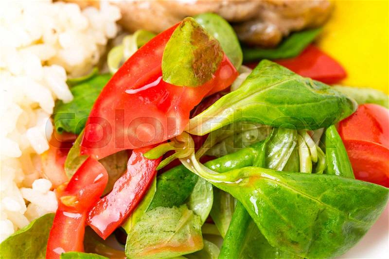 Roasted chicken fillet with rice and fresh vegetables as a garnish. Macro. Photo can be used as a whole background, stock photo