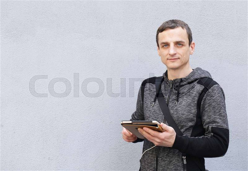 Portrait of a young man with an electronic tablet, stock photo