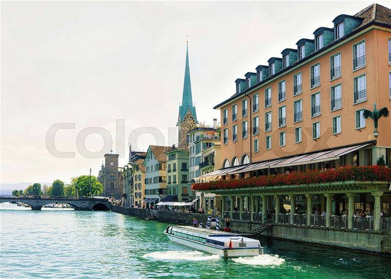 Fraumunster Church and ferry Limmat River quay in the city center in Zurich, Switzerland. People on the background, stock photo
