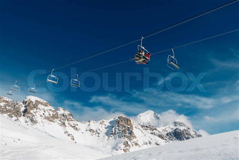 There are three man in the cabin of the cableway up to the mountain, stock photo