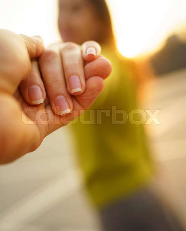 Follow me - happy young woman pulling guy\'s hand - hand in hand walking on a bright sunny day - concept of carefree modern life- focus on hands, stock photo