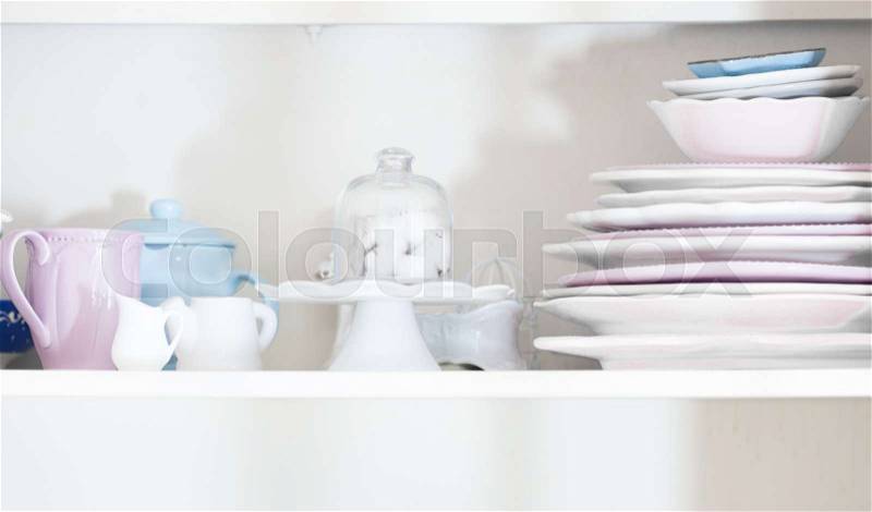 Rustic shabby chic style dishware in the kitchen chest of drawers, stock photo