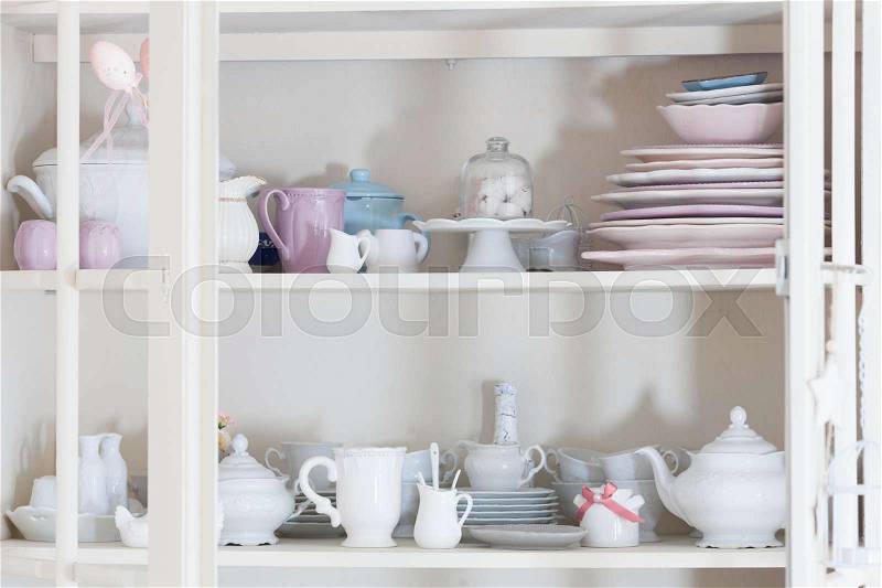 Rustic shabby chic style dishware in the kitchen chest of drawers, stock photo