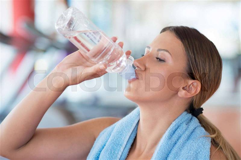 Fitness woman. Beautiful young girl in the gym on the treadmill drinking water. Fatigue, hand in head, wipes sweat, stock photo