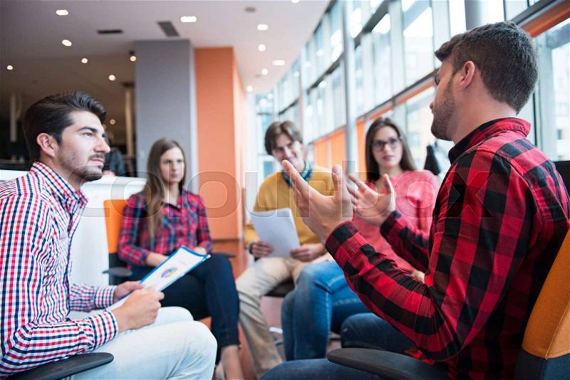 Shot of a group of young business professionals having a meeting. Diverse group of young designers smiling during a meeting at the office, stock photo