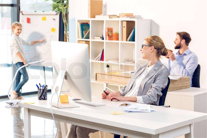 Woman working in home office, happy family with computer and whiteboard in office, stock photo