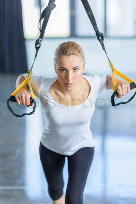 Concentrated sportswoman training with resistance band in sports center , stock photo