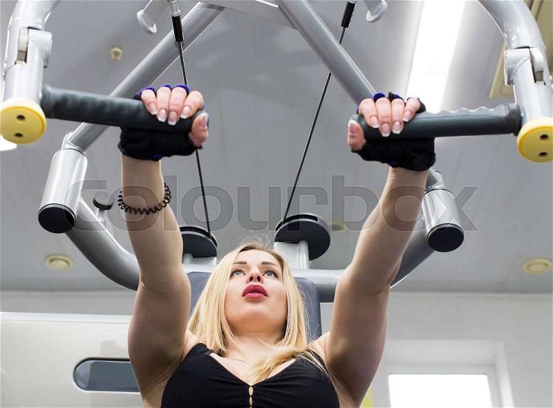 A young girl is engaged in power fitness in the gym, stock photo