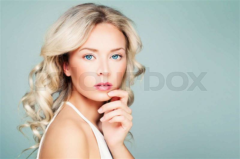 Young Woman Fashion Model with Blonde Curly Hair and Natural Makeup on Blue Banner Background, stock photo