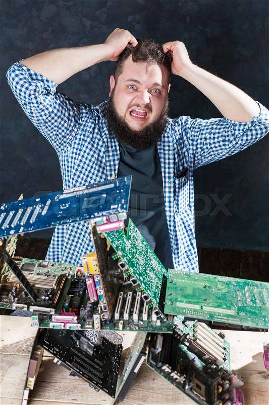 Repairman builds house of cards from motherboards. Engineer makes electronic components diagnostic. Broken computer hardware, stock photo