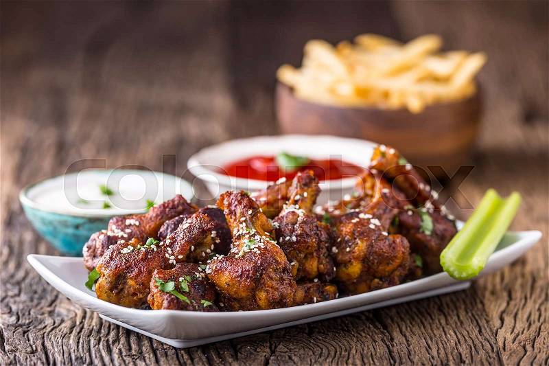 Chicken wings. Fried chicken wings in white bowl garlic dressing ketchup and potato fries, stock photo