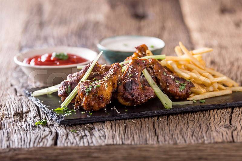 Chicken wings. Fried chicken wings in white bowl garlic dressing ketchup and potato fries, stock photo