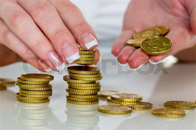 A woman stacking coins. save money for the future, stock photo