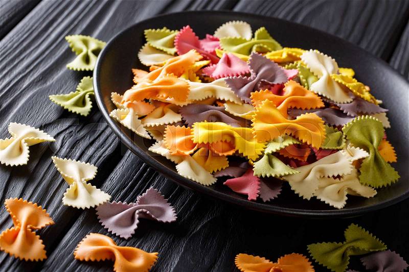 Traditional Italian colored farfalle paste close-up on a plate on a table. horizontal , stock photo