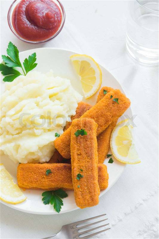 Fried fish fingers, mashed potatoes and lemon. Delicious lunch with fish sticks and vegetables, convenient seafood, stock photo