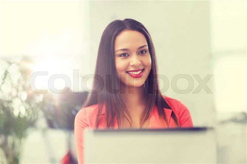 Business, startup, education and people concept - happy young african woman with laptop computer working at office, stock photo