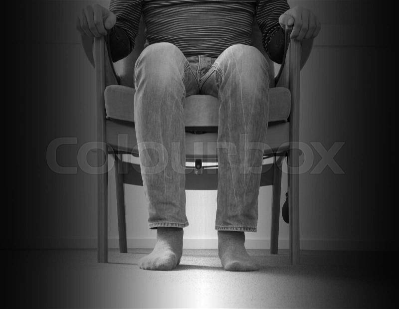 Man sitting in armchair, slightly creepy setting, stock photo