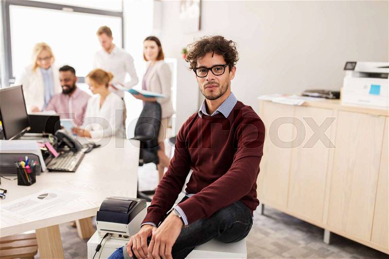 Business, corporate, people and teamwork concept - happy young man over creative team in office, stock photo