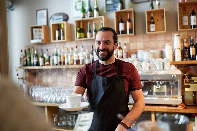 Small business, people and service concept - happy man or waiter with coffee cup serving customer giving him money at bar, stock photo