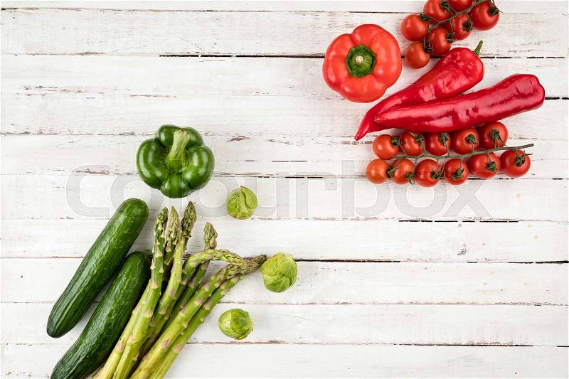 Green and red fresh seasonal vegetables on white wooden table background with copy space, stock photo