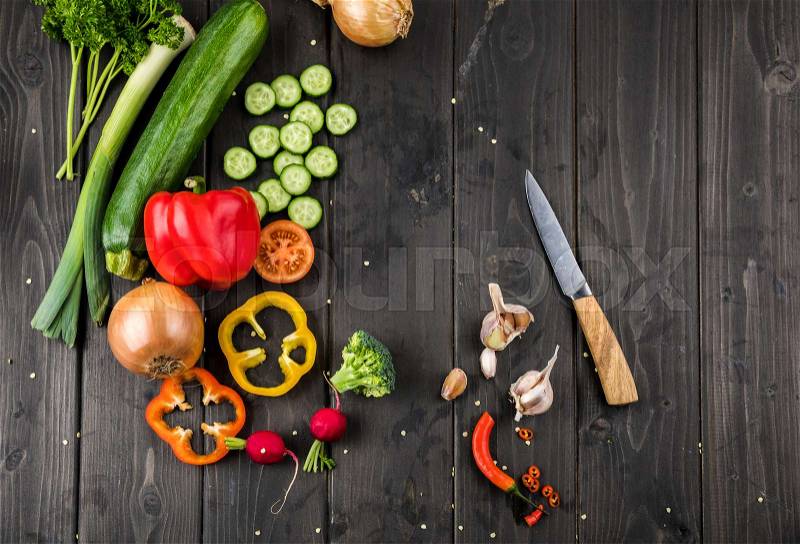 Top view of fresh seasonal vegetables and knife on wooden table background, stock photo