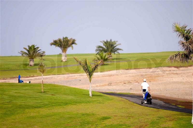 Golfer walking at path to next hole, stock photo