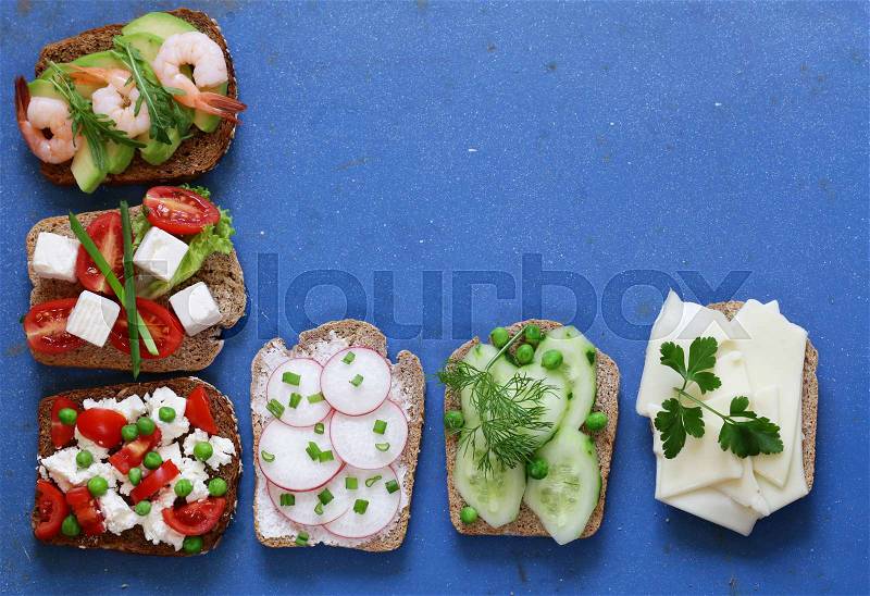 Variety of sandwiches with different fillings (avocado, shrimp, fish, ham, vegetables), stock photo
