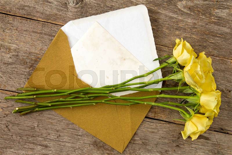 Yellow roses and love letter or note card with golden envelope, stock photo
