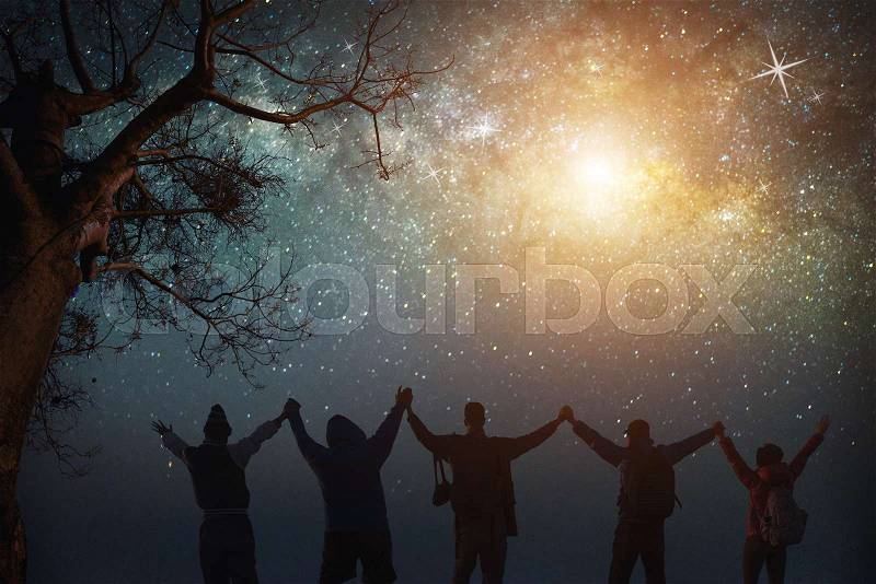 Milky Way.Night sky with stars and silhouette of standing happy peoples raised up arms.Blue milky way with people on the mountain.Background with universe.Night light landscape.Travel freedom concept, stock photo