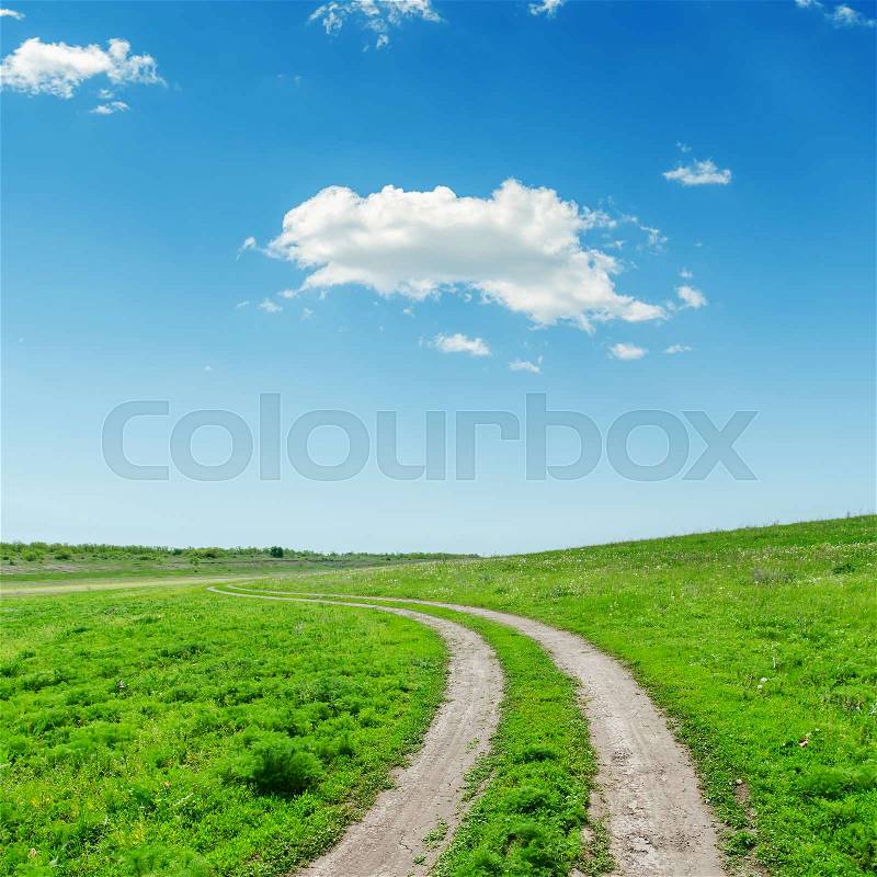 Road in green grass and clouds in blue sky, stock photo