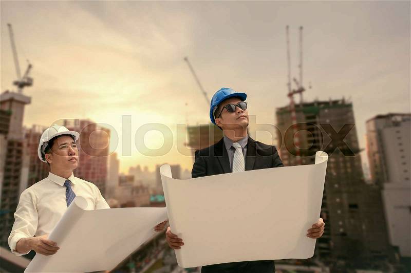 Asian businessman and engineer architect professional occupation corporate city looking away and holding construction idustrial plan for working concept, stock photo