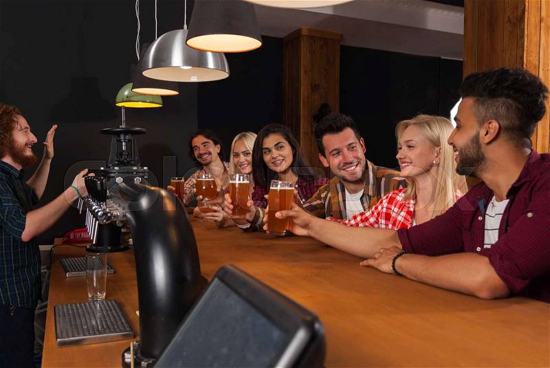 Young People Group In Bar, Barman Friends Sitting At Wooden Counter Pub, Drink Beer Communication Party Celebration, stock photo