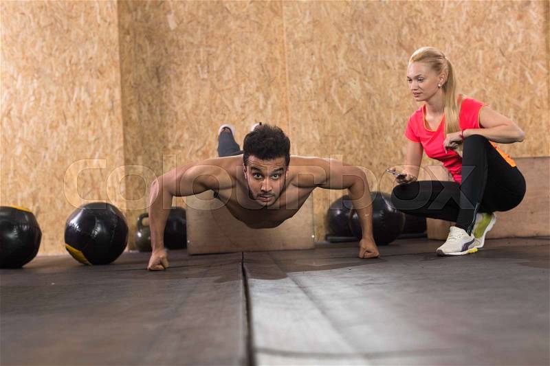 Sport Fitness People Crossfit Training, Young Healthy Hispanic Man Do Push Ups Woman Trainer Gym Interior, stock photo