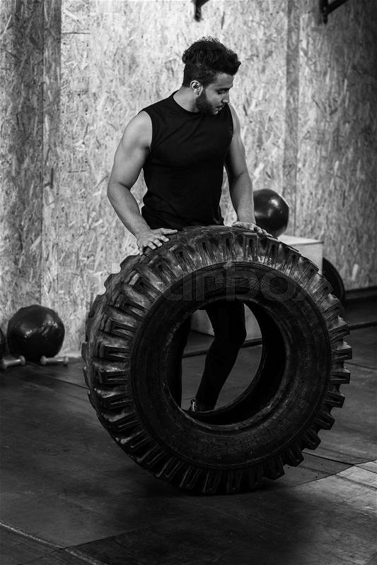 Sport Fitness Man Flipping Wheel Tire Crossfit Training, Young Healthy Guy Gym Interior, stock photo