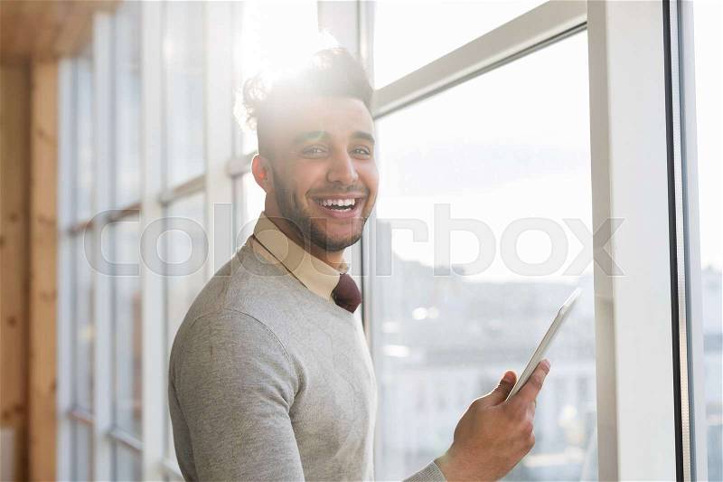 Hispanic Business Man Using Cell Smart Phone Stand in front Panoramic Window Happy Smiling Businessman In Coworking Center Office Interior, stock photo